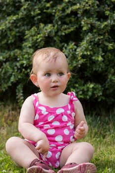 Happy cute little one year old girl outdoor, summer, with pink dress