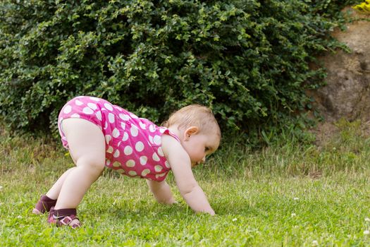 Happy cute little one year old girl outdoor, summer, with pink dress