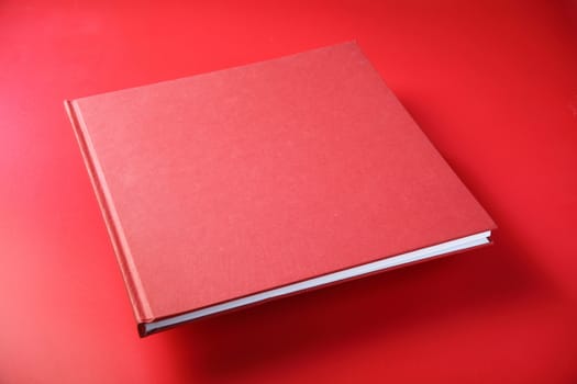 closed red book on the matt red background