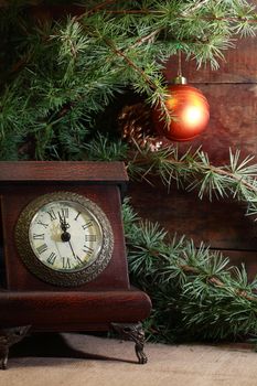 Christmas decoration. Vintage clock on old wooden background with Christmas decoration