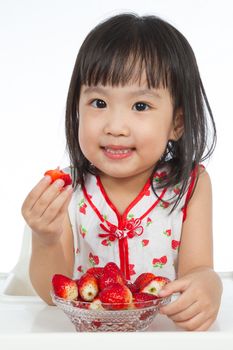 Asian Chinese children eating strawberries in plain white background.