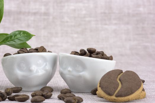 Delicious coffee cookies and coffee beans in a cute cups with facial expressions