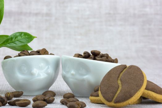 Delicious coffee cookies and coffee beans in a cute cups with facial expressions