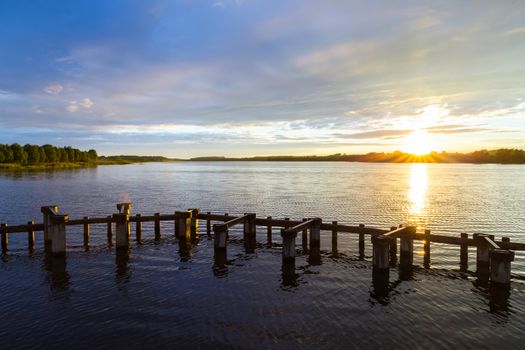 Landscape. Sunset on the shore of the pond in the summer.