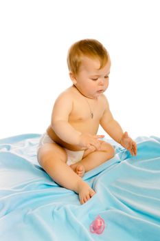baby in diapers on a blue coverlet. Studio