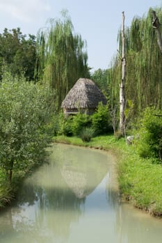 thatched hut on the river bank