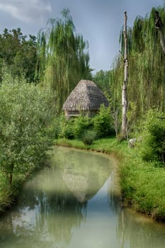 thatched hut on the river bank