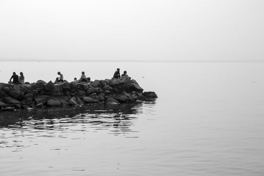 People relaxing on the lake rocks