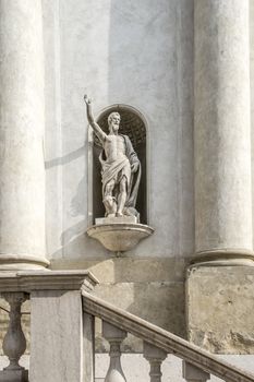 antique stone statue on the facade of an italian church