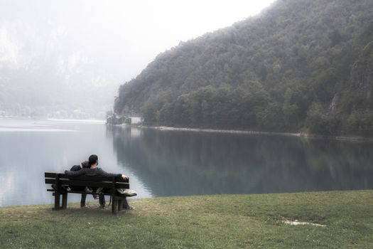 lovers on the bench in front of the lake