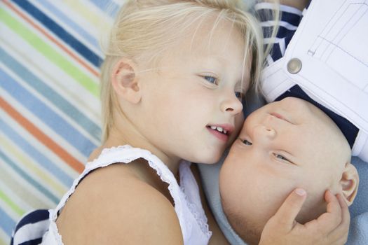 Cute Little Sister Laying Next to Her Baby Brother on Blanket.