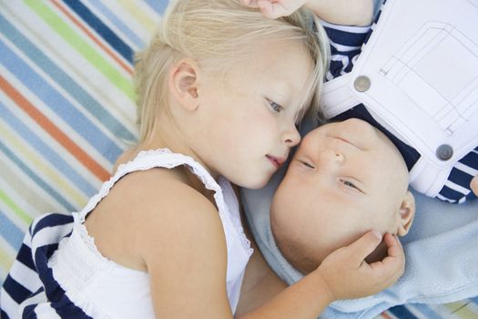 Cute Little Sister Laying Next to Her Baby Brother on Blanket.