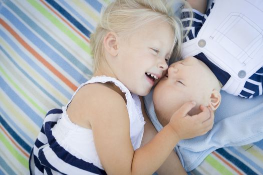 Cute Little Sister Laying Next to Her Baby Brother on Blanket.