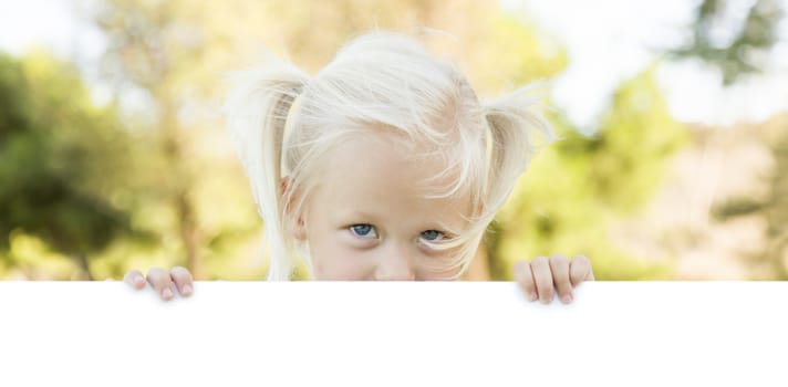 Cute Little Girl Outside Holding Edge of White Board with Room For Text.