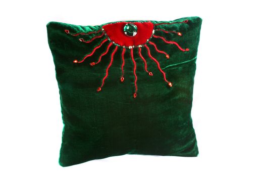 A luxurious pillow with a green velvet color and artistic design on it