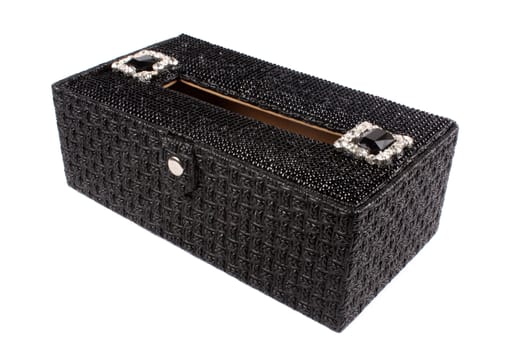A luxurious tissue container with a beautiful design on its black surface, on white studio background.