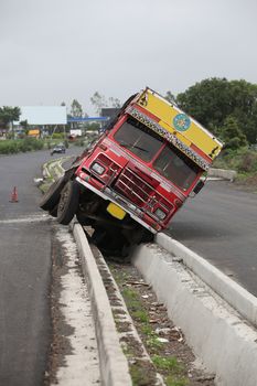 An accident of a truck stuck in the rainwater drain passage on an Indian highway