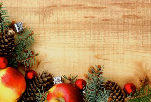 Arrangement of Spruce Branch, Red Baubles, Fir Cones and Delicious Apples closeup on Wooden background as Frame