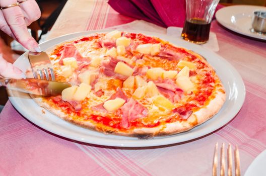 Delicious spicy Pizza Hawai in a pizzeria.