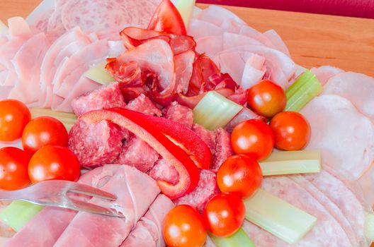 Party-meat platter with different sausages, cherry tomatoes and celery.