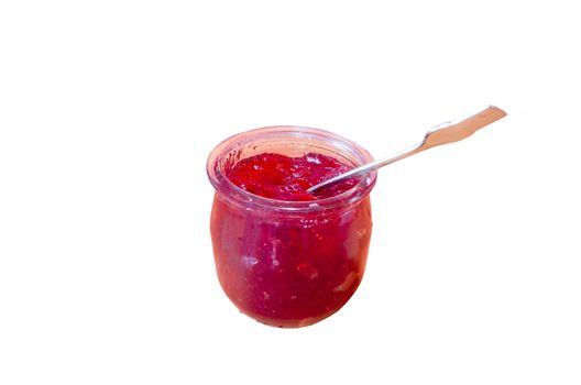 Homemade red jam in a small jar with spoon against a white Hintergrung.