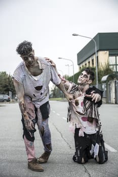 Two male zombies standing in empty city street looking at camera