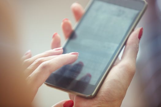Hands of woman using smartphone