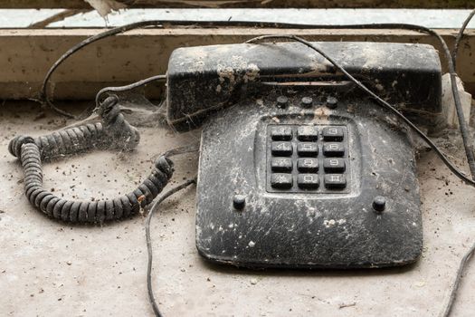 Detail of the old disused phone overgrown with cobwebs