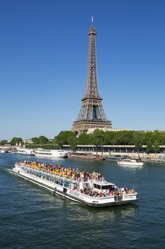 PARIS,FRANCE - JUNE 16, 2015: riverboat on Seine river in Paris with Eiffel tower, most visited monument of France