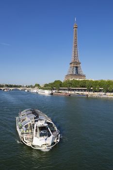 PARIS,FRANCE - JUNE 16, 2015: riverboat on Seine river in Paris with Eiffel tower, most visited monument of France
