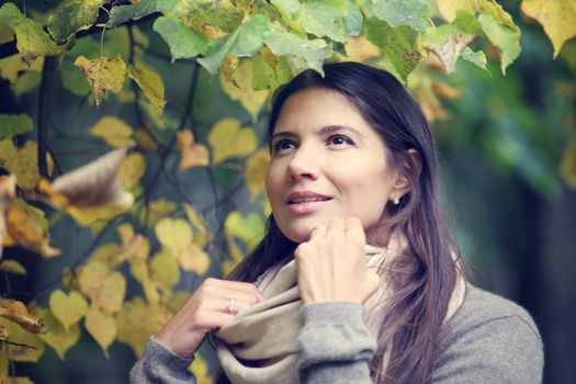 Beautiful brunette woman portrait on autumn tree background
