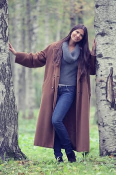 Beautiful brunette woman fashion portrait in birch forest