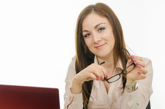 Cute little girl is a teacher sitting at a desk with a laptop, books and notebooks