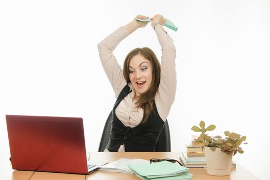 Cute little girl is a teacher sitting at a desk with a laptop, books and notebooks