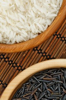 Arrangement of White and Brown Rice in Wooden Bowls Cross Section on Straw Mat background