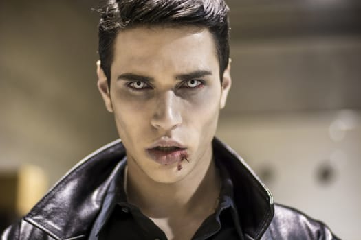 Close up Face of a Handsome Vampire Man in Leather Clothing, with Blood on his Mouth, Looking at the Camera.