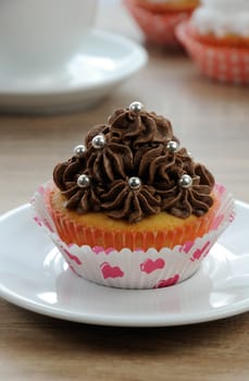 Muffin decorated with chocolate cream in paper packaging