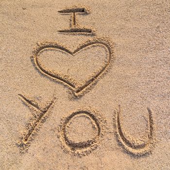 In the picture an inscription on the sand "I love you".