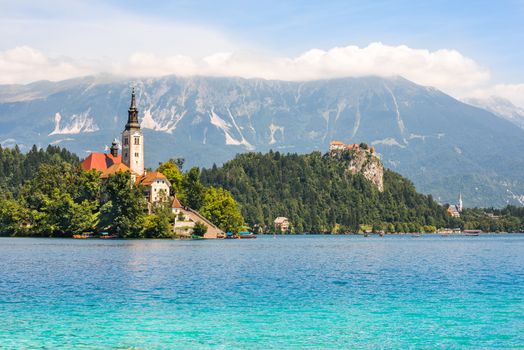 Little Island with Catholic Church and Bled Castle on Bled Lake, Slovenia with Mountains in Background