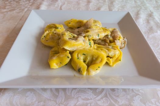 Italian pasta "Tortelloni" with mushrooms (Porcini) ,cream ,parmesan and herbs,served on white dish at restaurant.