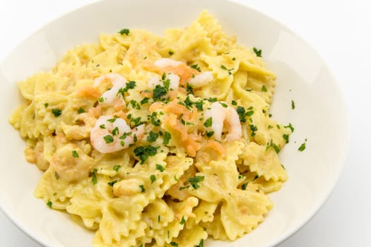 italian traditional pasta called butterflies with shrimp salmon and basil