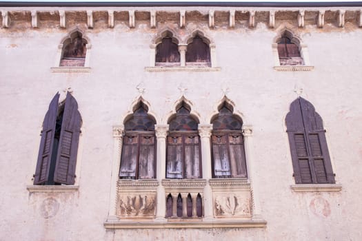 old windows on a medieval palace facade in Verona, Italy