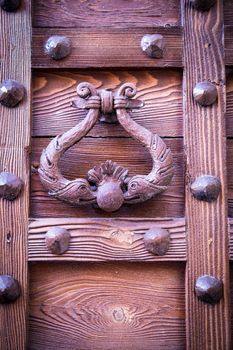 ancient door knocker of a medieval wooden portal