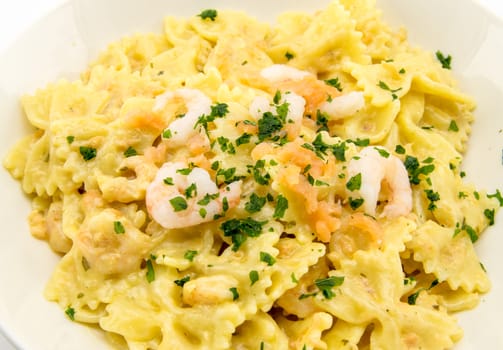 italian traditional pasta called butterflies with shrimp salmon and basil