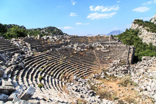 Top view of amphitheater of Termessos Antique City in Antalya, on cloudy blue sky background.