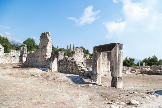 View of stones of destroyed and damaged Tlos Ancient City, on blue sky background.