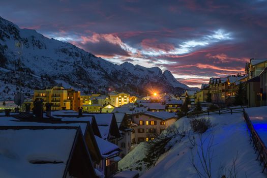 winter sunset in alpine pass village with snow