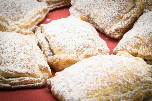 handmade biscuits of puff pastry stuffed with chocolate and covered with powdered sugar