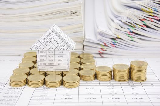 House with step of gold coins on finance account have paper of report and step overload of old paperwork as background.