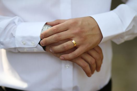 General view of the golden wedding ring on the ring finger of a man's hand